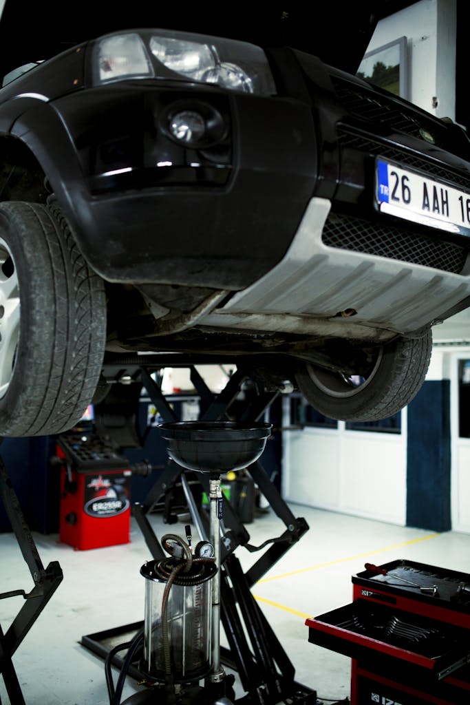 Elevated SUV in an automotive repair shop with visible license plate.